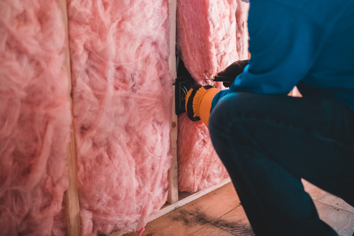 Handwerker montiert eine Leitung an einer geöffneten Wand